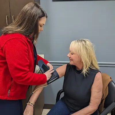 Nurse with a patient checking blood presure prior to testing